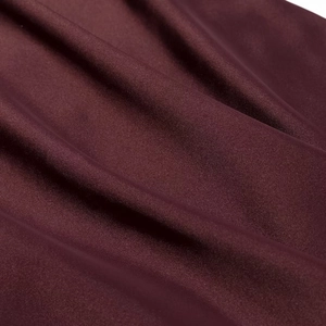 Détail macro du tissu satiné bordeaux montrant la haute densité et le drapé soyeux