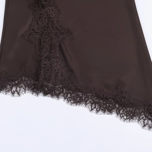 Close-up of chocolate satin fabric with black eyelash lace trim on the bottom hem