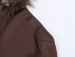 Detail of luxurious brown satin dress with elegant ostrich feathers around the neckline