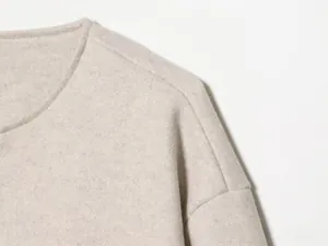 Détails de la veste bombardier en laine beige avec col rond et coutures d'épaules tombantes