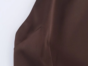 Close-up of side seam and pocket stitching on dark brown halter neck feather dress