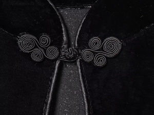 Detaillierte Makroansicht des traditionellen chinesischen Knotens am schwarzen Samtkleid