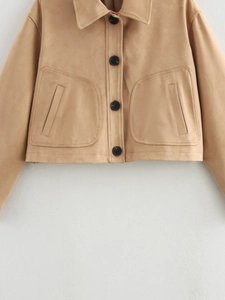 Detail view of the camel faux suede jacket featuring large front pockets and black buttons