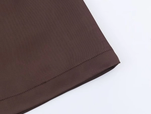 Detail view of the deep brown dress hem featuring professional double-needle flat stitching