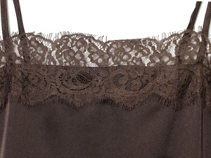 Dettaglio del top in raso marrone scuro con pizzo ciglia raffinato e spalline