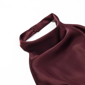 Détail d'une robe en satin bordeaux montrant le licou avec deux boutons élégants