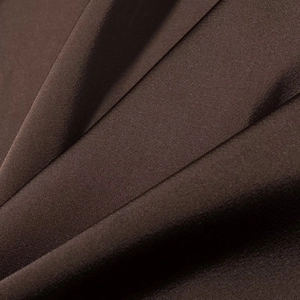Nahaufnahme von kaffeebraunem Spitzenkleid-Stoff mit feiner Textur und Seidenglanz