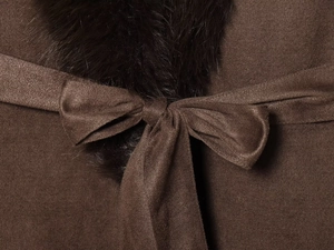 Detail eines dunkelbraunen Mantels mit schwarzem Kunstfellkragen und elegantem Taillengürtel