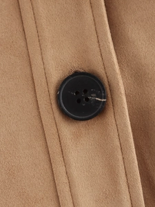 Detailed view of camel suede jacket texture with a black round button and fine stitching