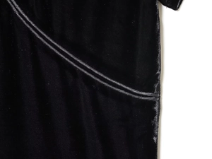 Makroaufnahme von hochwertigem schwarzem Samtstoff mit präzisen Nähten und Paspeln am Kleid