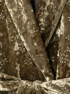 Detail of velvet blazer with silver sparkle print, featuring notched lapels and belted waist