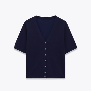 Detail of navy V-neck short sleeve knit cardigan with delicate white buttons texture