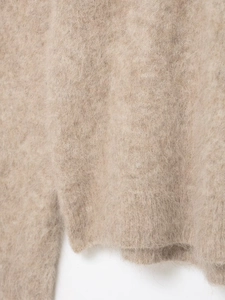 Dettaglio macro della maglia jacquard beige morbida con texture in mohair soffice