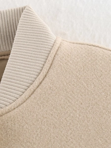 Macro detail of beige tweed jacket collar with ribbed knit texture and fine stitching