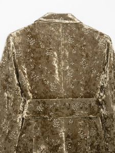Back view of velvet blazer with metallic floral patterns and matching waist belt