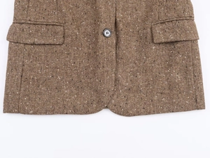 Détail du blazer en tweed à chevrons marron montrant la texture et la poche à rabat