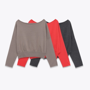 Détail de pulls en maille fine gris, rouge et anthracite avec des finitions côtelées