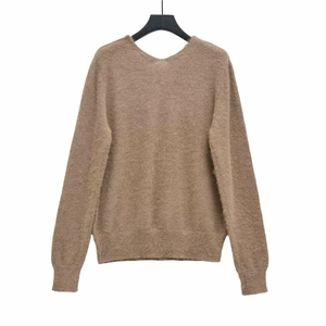 Detailed close-up of brown knit sweater texture with soft fibers and ribbed hem detail