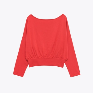 Gros plan du pull en tricot rouge avec col bateau et détails d'ourlet à la taille côtelé