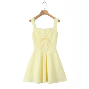 Détail de robe courte jaune dos nu avec dentelle au décolleté et petit nœud déco