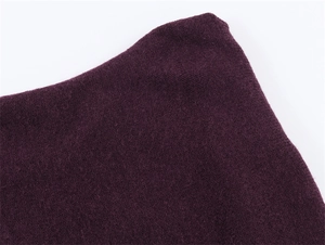 Macro shot showing deep purple knit fabric texture and soft wool blend fibers detail