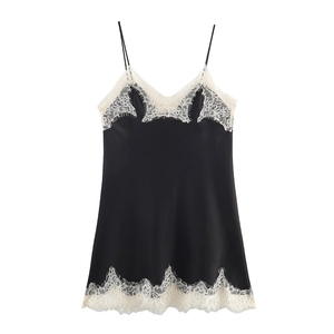 Détail de la robe en satin noir avec dentelle blanche délicate au niveau de l'encolure en V