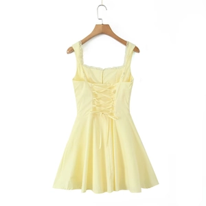 Détail de robe jaune clair avec bordure en dentelle blanche et laçage au dos