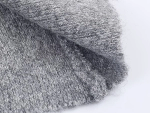 Close-up of soft grey gradient knit fabric with a fuzzy mohair-like texture and weave