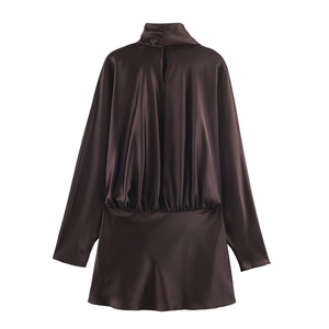 Detail of chocolate satin mini dress featuring high neck and pleated waist texture