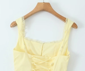Détail de la robe jaune clair avec bordure en dentelle et dos lacé style corset rétro