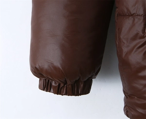Détail de doudoune marron foncé brillant avec poignets élastiques coupe-vent isolants