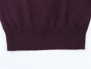 Detailed view of the dark purple ribbed hem on this elegant knitted sweater garment