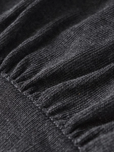 Gros plan sur la maille noire montrant des détails plissés et une texture de tissu douce