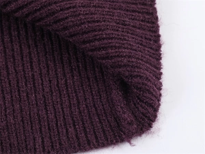 Close-up of deep purple ribbed knit texture showing thick yarn and detailed stitch patterns
