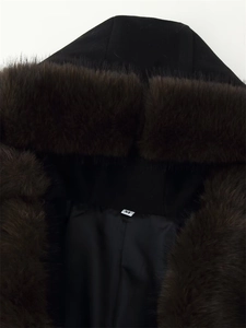 Close-up of the plush faux fur collar and size M label on a slim black winter coat
