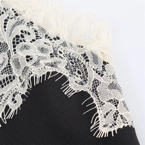 Gros plan détaillé sur tissu noir avec dentelle de cils blanche et motifs floraux