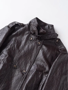 Detail of dark brown PU leather jacket featuring stand collar and textured finish