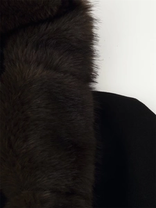Detailed macro shot of thick dark faux fur texture on the stylish winter coat collar