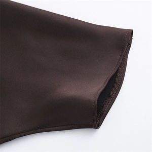 Detailed macro view of dark brown satin dress fabric with premium smooth stitching