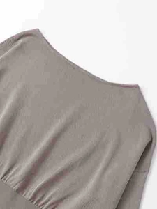 Détail d'un pull en maille taupe montrant l'encolure et la texture fine du tissu côtelé