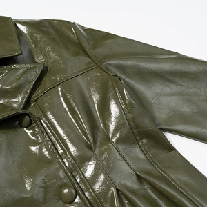 Detailed view of olive green patent leather jacket with lapels and matching buttons