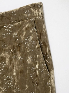 Macro shot of metallic velvet fabric with silver floral sequins and invisible zipper