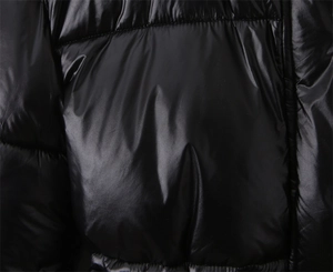 Gros plan de la veste matelassée noire brillante avec matière coupe-vent et texture
