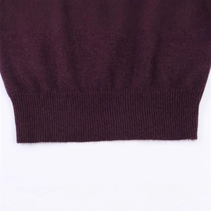 Close-up of deep purple knit sweater featuring high-quality ribbed hem detail