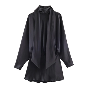 Detail view of black satin mini dress featuring scarf collar and elegant front draping