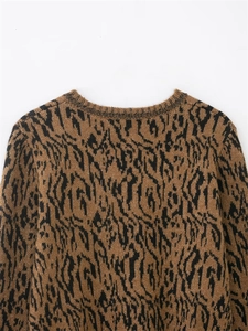 Détail de l'encolure ronde et texture imprimé animal marron sur le gilet en maille