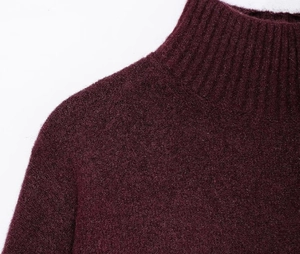 Detailed macro view of the fluffy burgundy turtleneck knit fabric and collar stitching