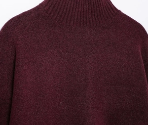 Detail of burgundy knit sweater showing the mock neck collar and soft ribbed texture