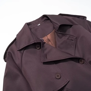 Close-up of double-breasted lapel trench coat with shoulder straps and resin buttons