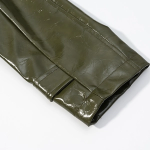 Detailed close-up of military green faux leather cuffs with decorative straps and stitching